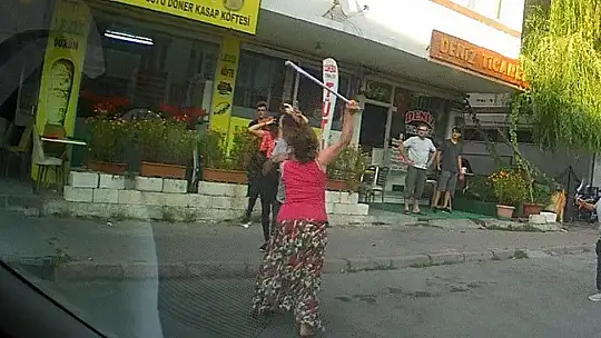 Eli sopalı kadın önüne gelen erkeği dövdü