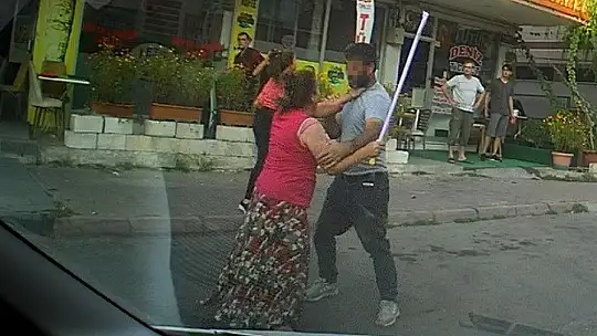 Eli sopalı kadın önüne gelen erkeği dövdü