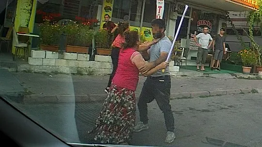 Eli sopalı kadın önüne gelen erkeği dövdü
